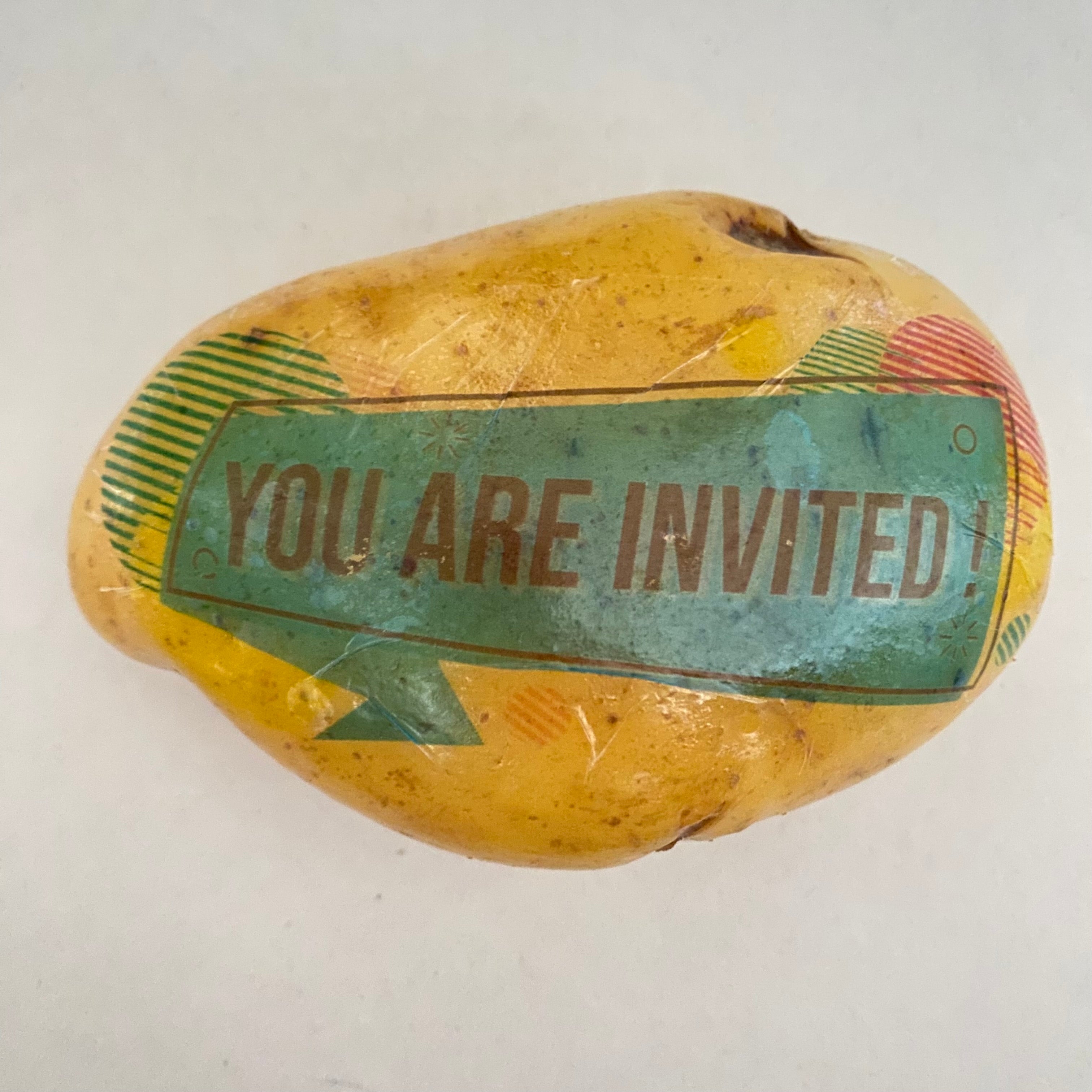 Eine Kartoffel mit einer art Sprechbalse als Aufdruck. Diese sagt "You are invited!"