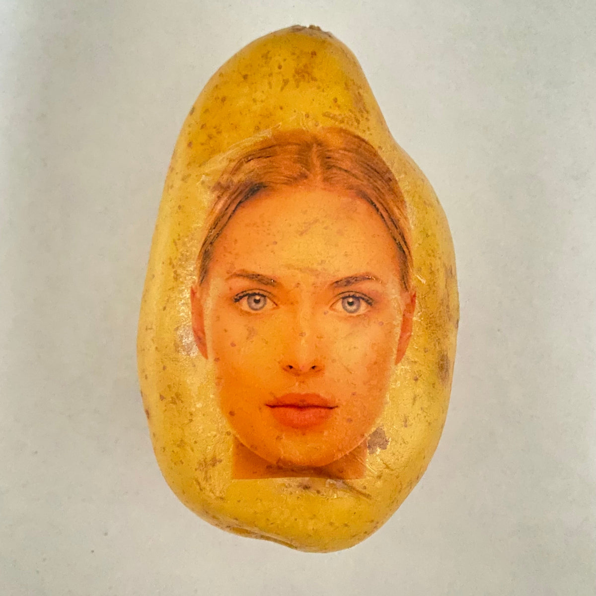 Eine Kartoffel mit dem Foto einer blonden Frau als Aufdruck